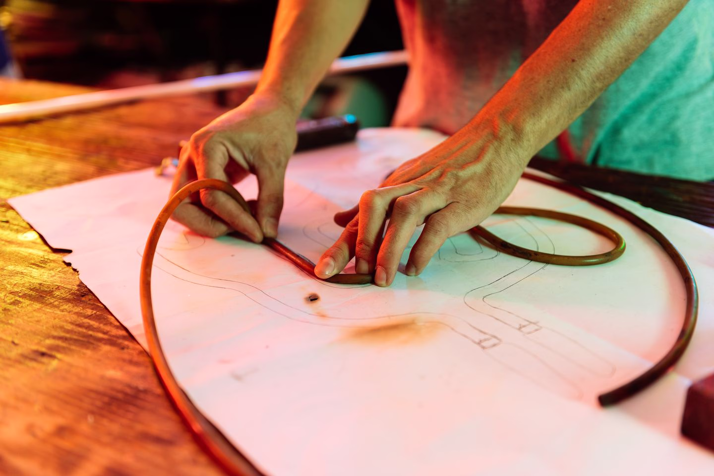 Hands shaping flexible tubing for a dimensional sign — Source Select.