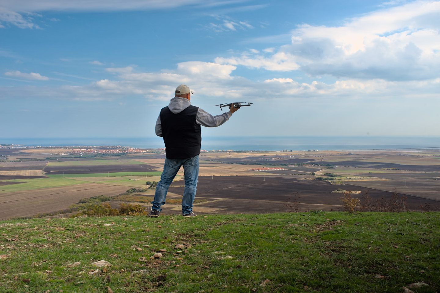 Drone operator standing in an open landscape — Source Select.