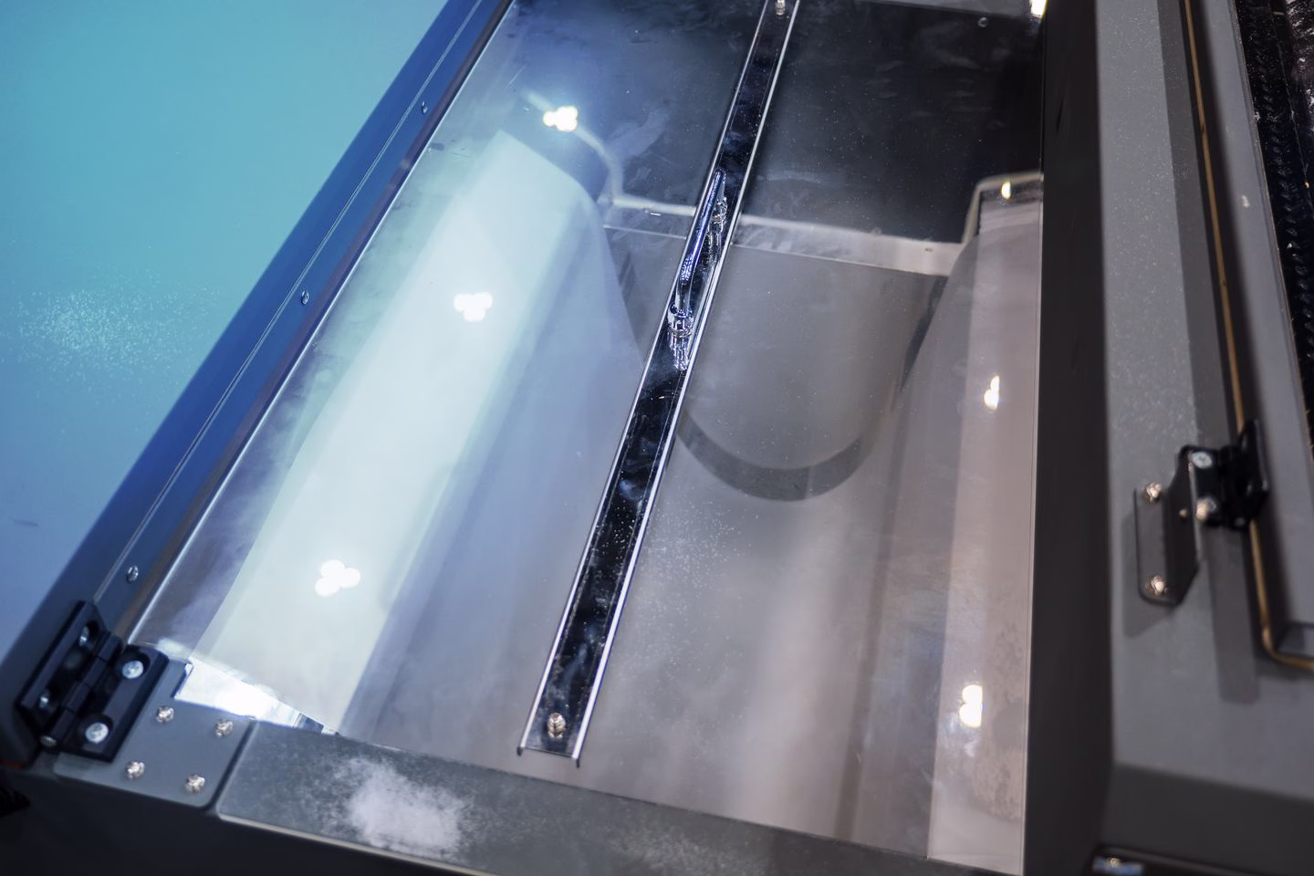 Transfer film moving through a DTF adhesive processing unit — Source Select.