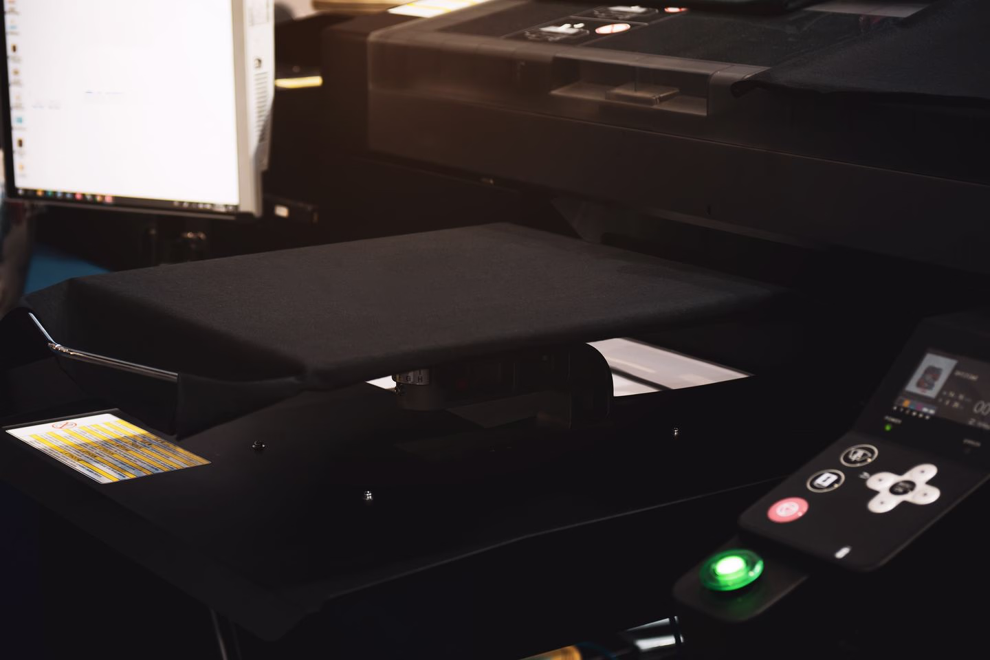 Dark shirt positioned in a direct-to-garment printer — Source Select.