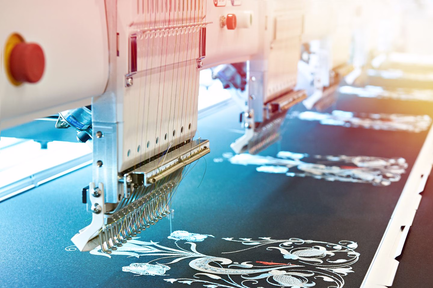 Embroidery machine stitching blue fabric — Source Select.