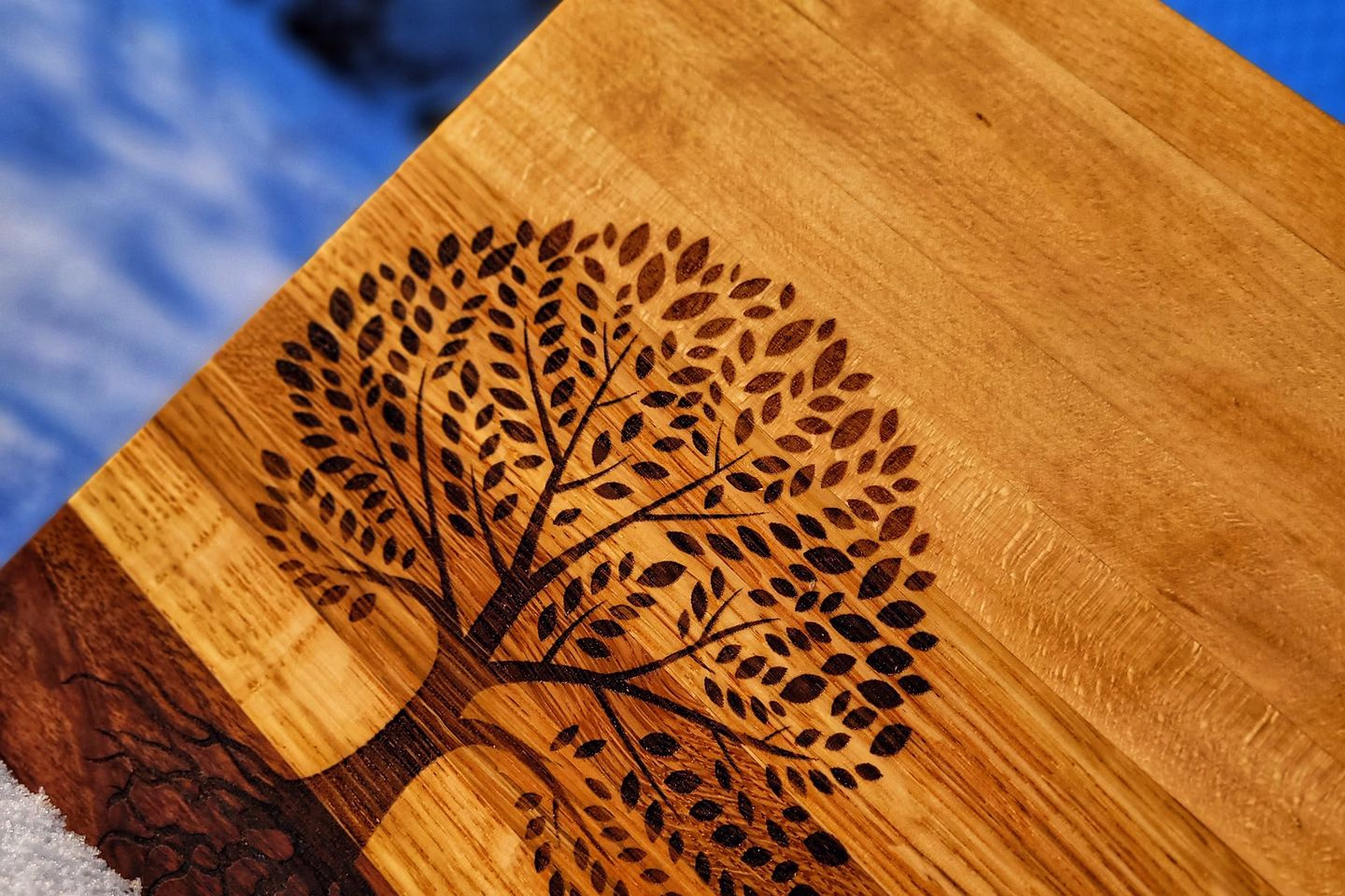Finished engraved wooden product held outdoors — Source Select.