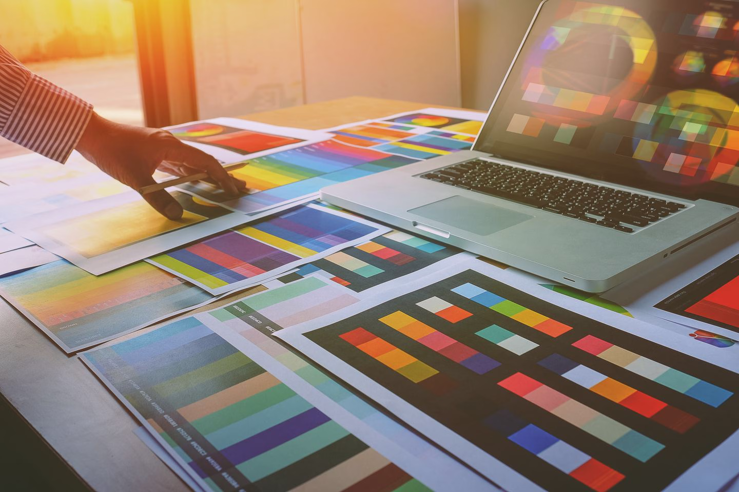 Designer reviewing colour swatches and printed artwork — Source Select.