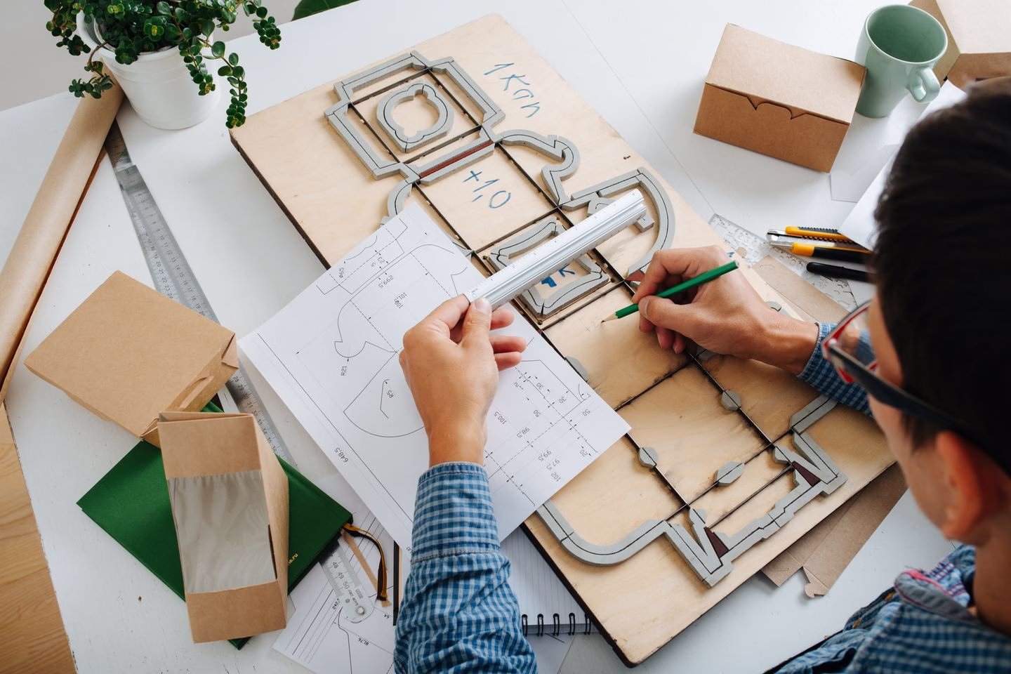Designers reviewing packaging dielines at a worktable — Source Select.