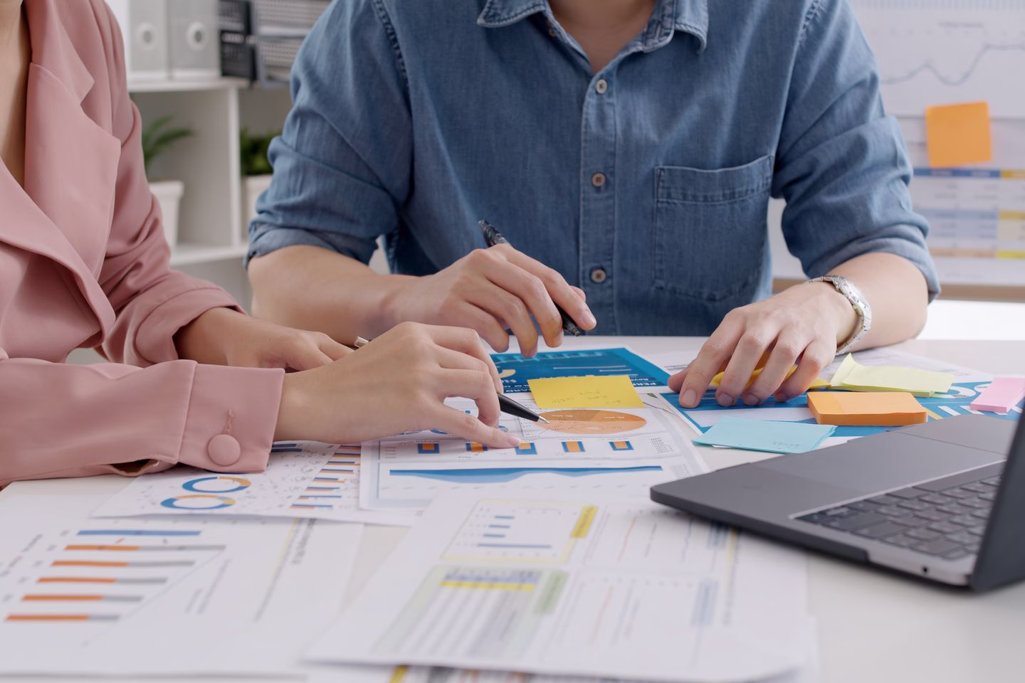 Colleagues discussing printed charts and search performance reports — Source Select.