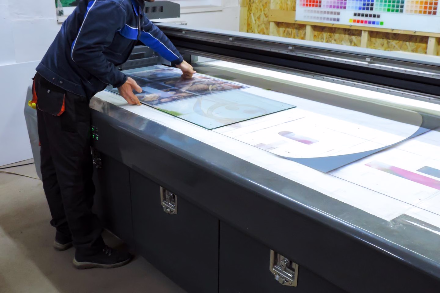 Rigid sheet material positioned in a UV printing machine — Source Select.
