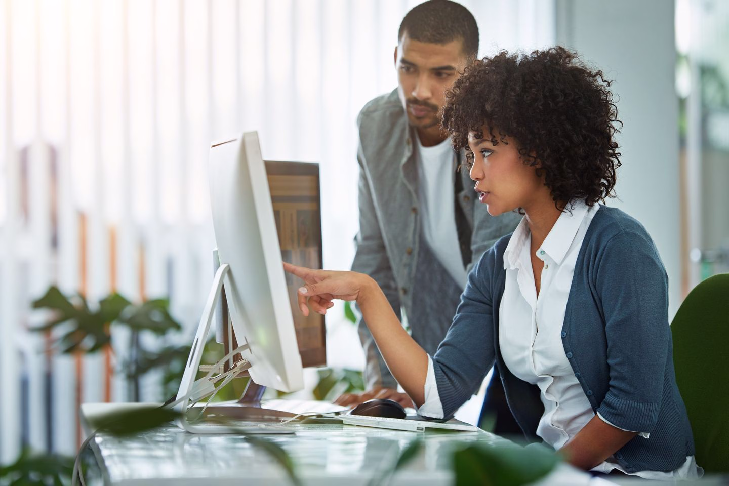 Colleagues planning a website together at a laptop — Source Select.