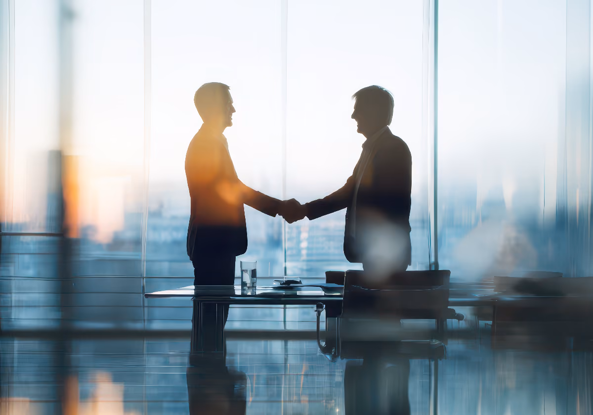 Two people shaking hands in a bright office