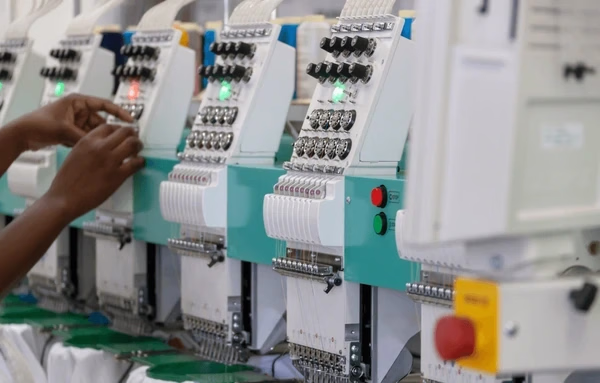 Operator working with embroidery machines — Source Select.