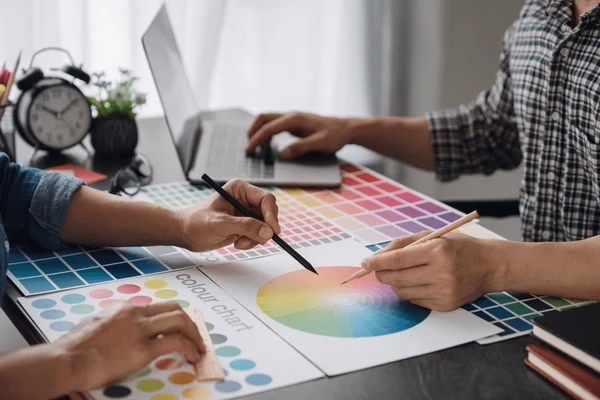 Designers choosing colors using printed swatches — Source Select.